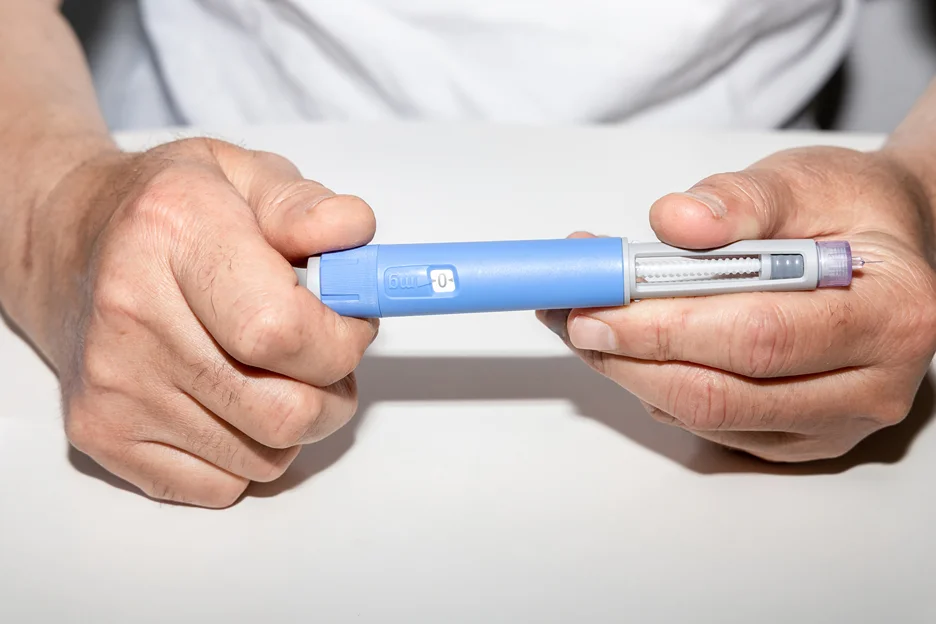 a man holding his semaglutide pen 