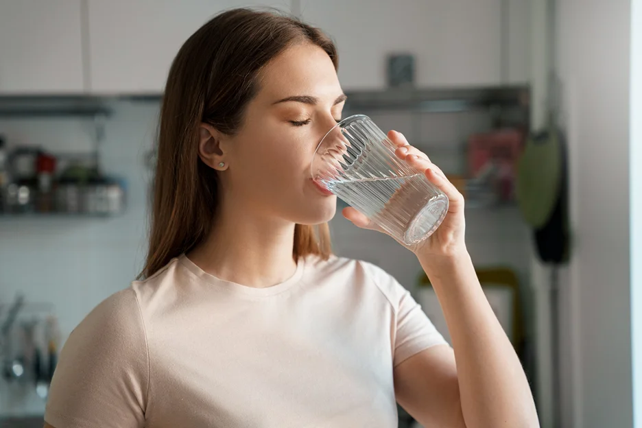 a woman drinks a glass of water