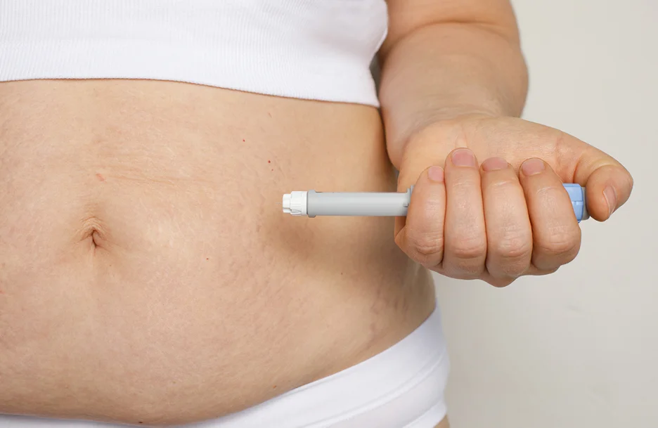 a woman injects semaglutide pen on her belly